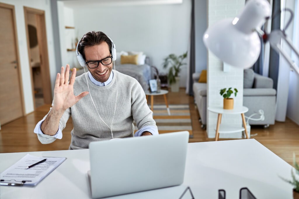 happy entrepreneur waving during a video call while working at h